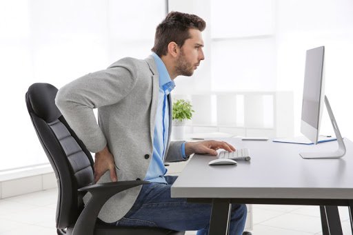 homem sentado com dor na zona lombar